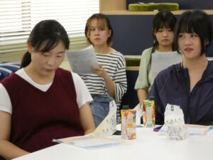 昼食をとりながら説明を聞く参加者ら